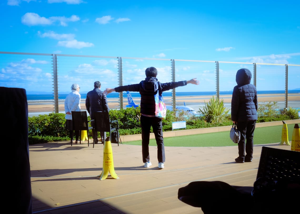People waving goodbye at planes in Beppu